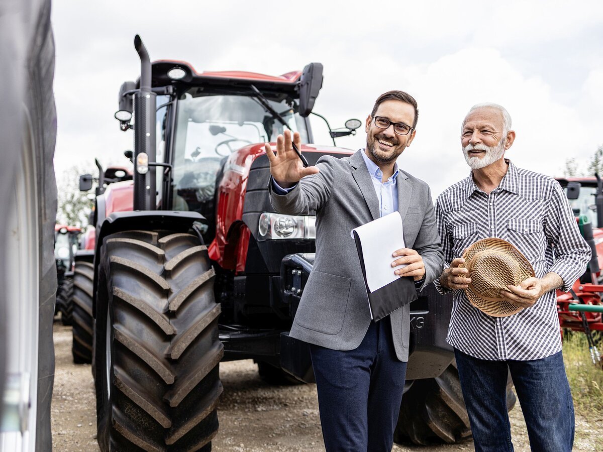 Farmer buying new tractor machine for agricultural business at dealership.